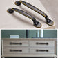 Set of two black drawer cabinet handles with gold-trimmed curved pulls