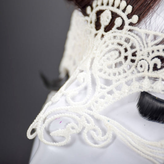 White lace cat king masquerade mask close-up, curled filigree around eye area