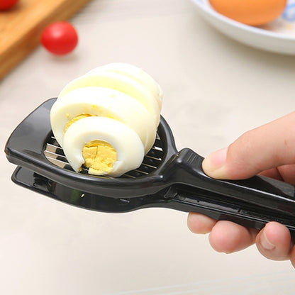 Black egg slicer tool with circular cradle and slicing blades, held in hand