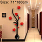 Black vase wall sticker with red flowers arranged along curved branch design
