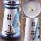 Close-up of white and blue lighthouse decor with sail detail and window cutouts