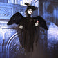 Hanging ghost decoration in black, side view with wide hat, pale face, and outstretched arms