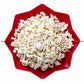 Red foldable silicone popcorn maker open, filled with white popcorn