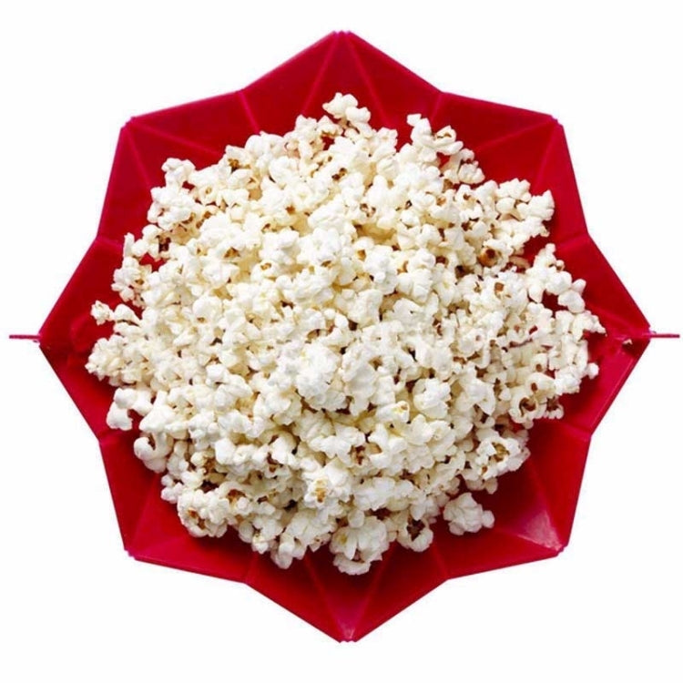 Red foldable silicone popcorn maker open, filled with white popcorn