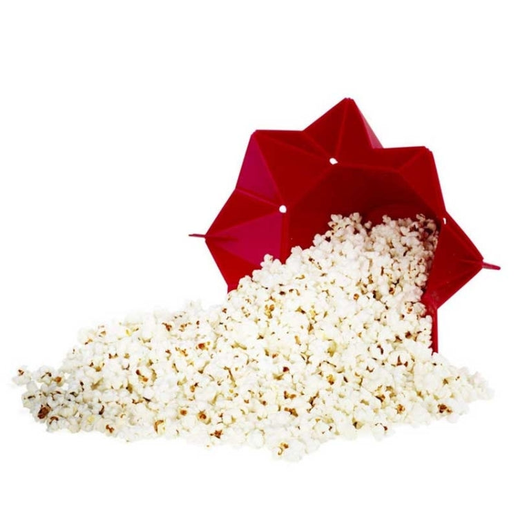 Red foldable silicone popcorn maker with white popcorn spilled out of the opening
