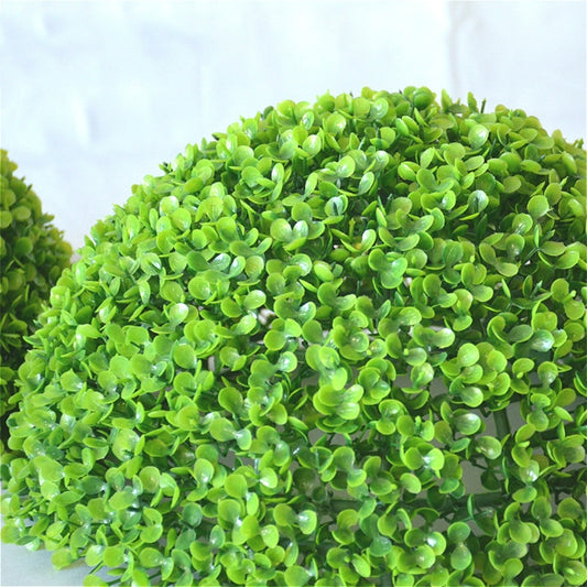 Close-up of bright green artificial plant ball topiary foliage texture