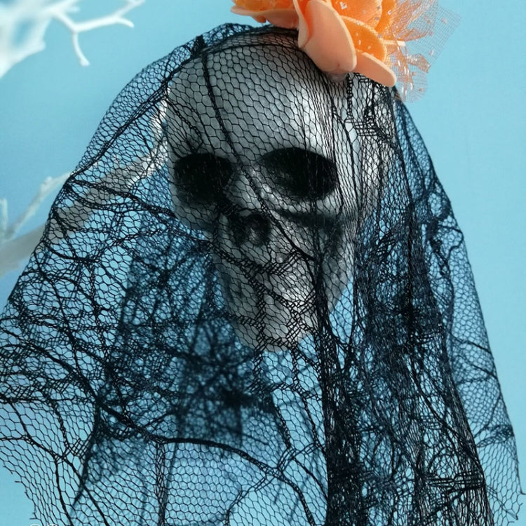 Close view of black tulle hanging skull ornament with orange flower headpiece