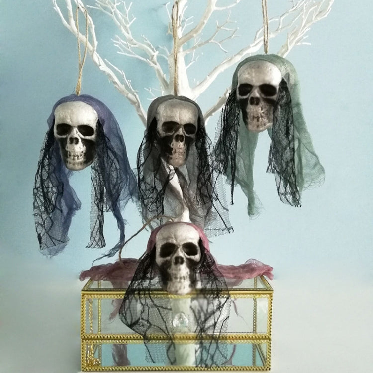 Assorted hanging skull ornaments with tulle veils and colored flower accents on gold display