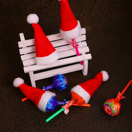 Set of mini red felt Santa hats with white trim and pom on candy lollipop sticks
