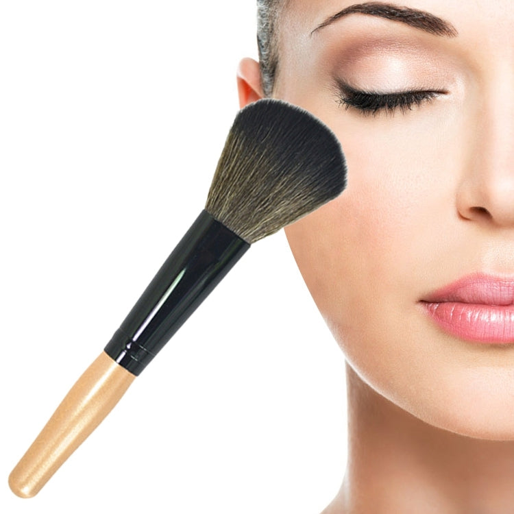 Angled makeup powder brush with gold handle and soft dark bristles