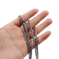 Metal snake-chain pet collar links with round rings, shown held in an open hand