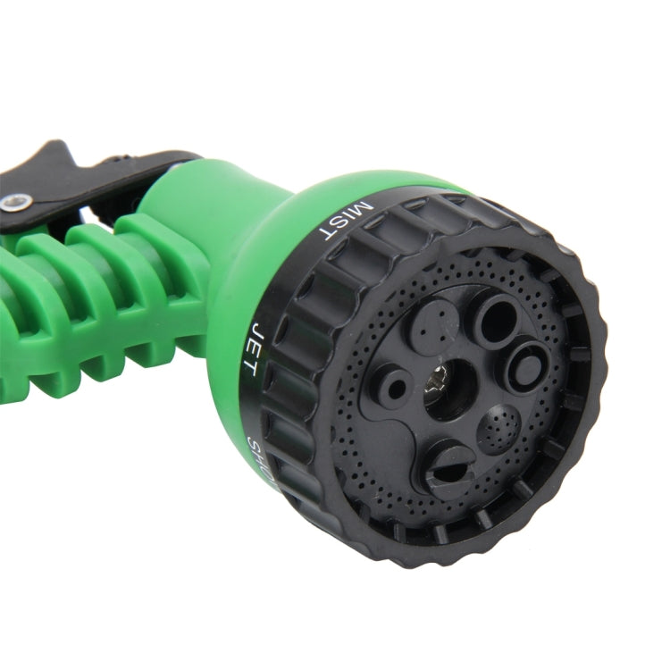 Round black multi-setting spray head on a green garden water gun, close-up