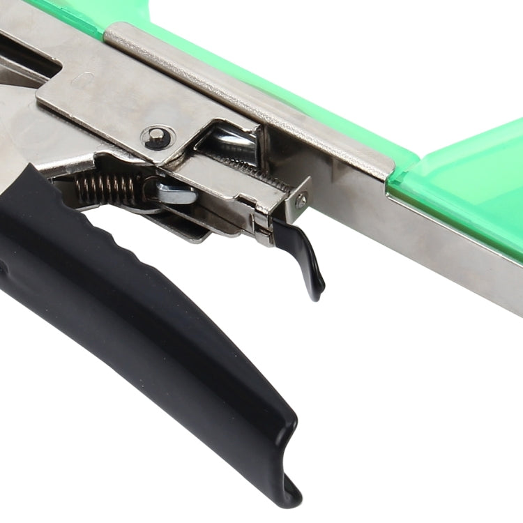 Green tape tying machine close-up of metal jaws and black trigger handle