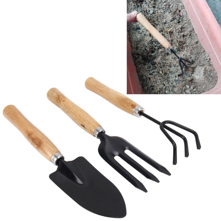 Mini garden hand tool set with wooden handles and black metal spade, fork, and rake