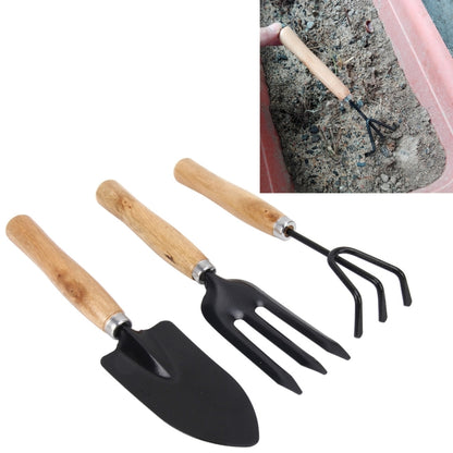 Mini garden hand tool set with wooden handles and black metal spade, fork, and rake