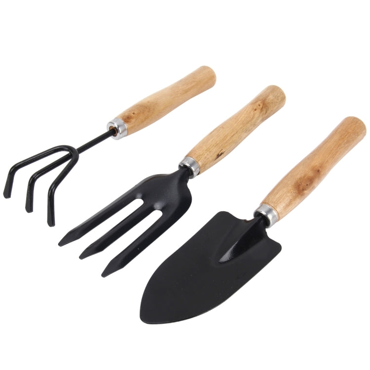Mini garden tool set with black spade, three-prong fork, and rake on wooden handles