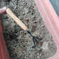 Mini garden spade with wooden handle held in soil