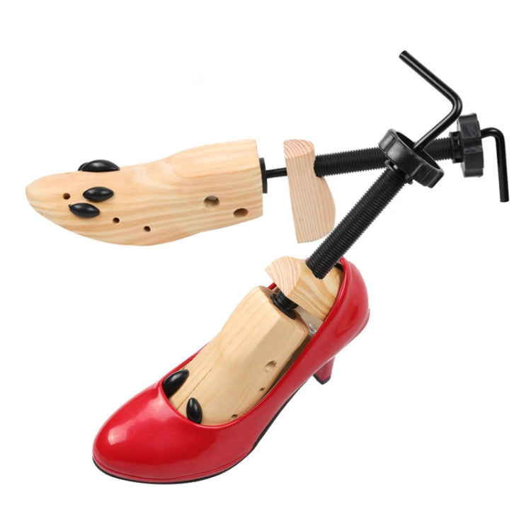 Wooden shoe stretcher holding a red high-heel pump with black screw expander