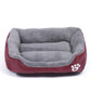 Gray teddy-fleece dog kennel mat with curved bolsters and burgundy base, paw print