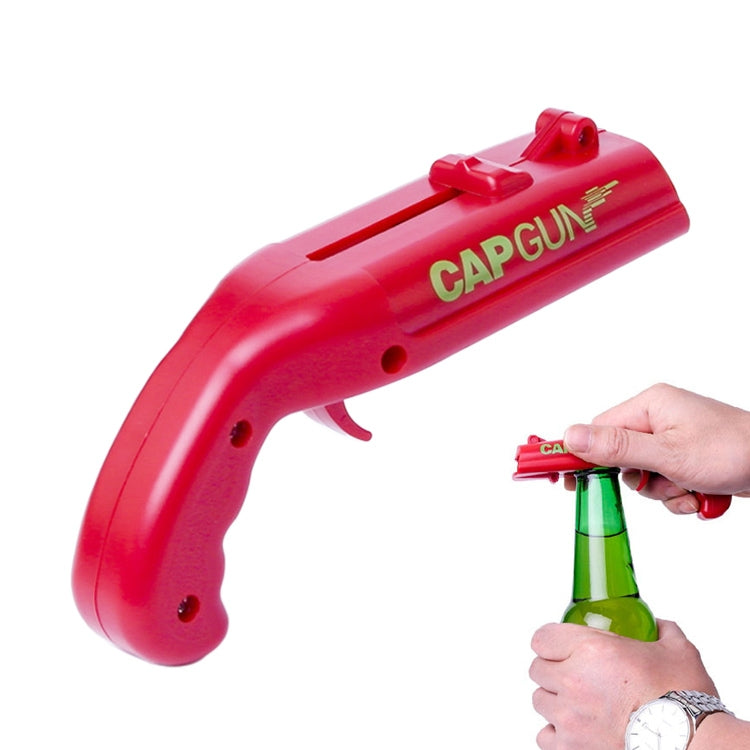 Red cap gun-style bottle cap opener removing a cap from a green bottle.