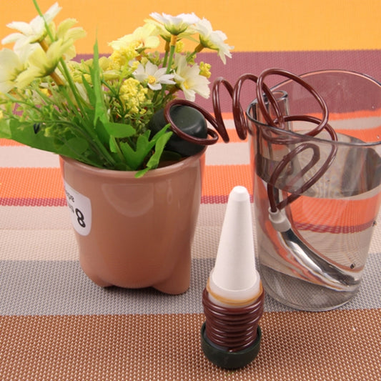 Automatic drip irrigation kit with coiled brown spring, white nozzle, and tubing clips