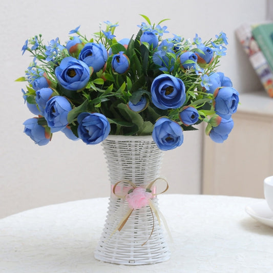 White ribbon-tied flower vase with blue rose bouquet and a small pink bow detail
