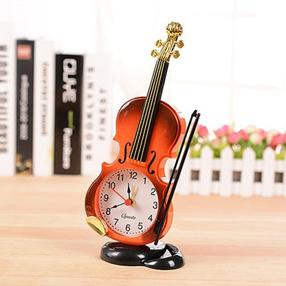 Violin-shaped alarm clock with pen holder, orange-red with gold accents and black base