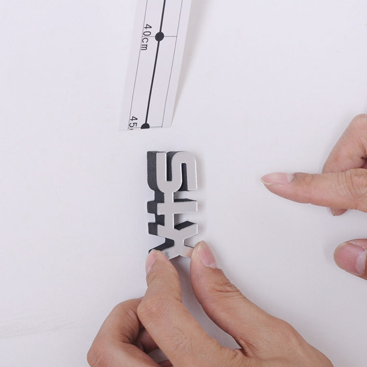 DIY wall sticker clock: hands pressing a black numeral piece onto a wall