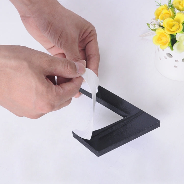 DIY wall sticker clock: hands applying a black adhesive number strip