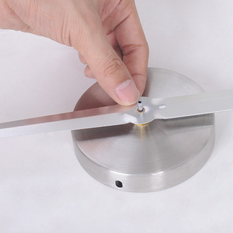 Center of mirror-style clock being attached to a silver circular base