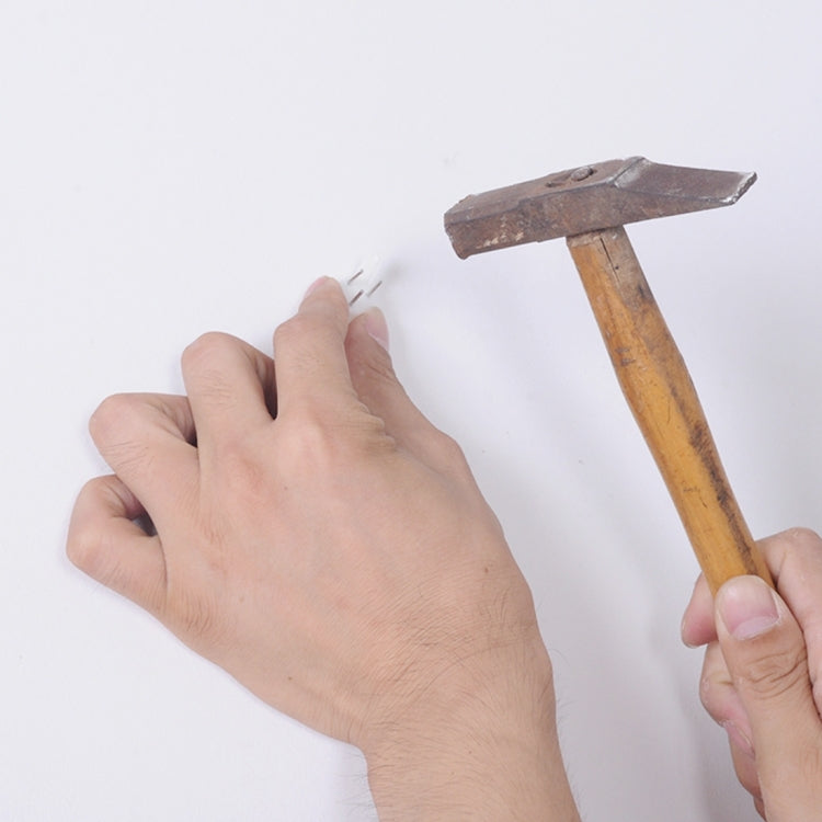 Hands pressing clock sticker pieces with a flat tool on a wall surface