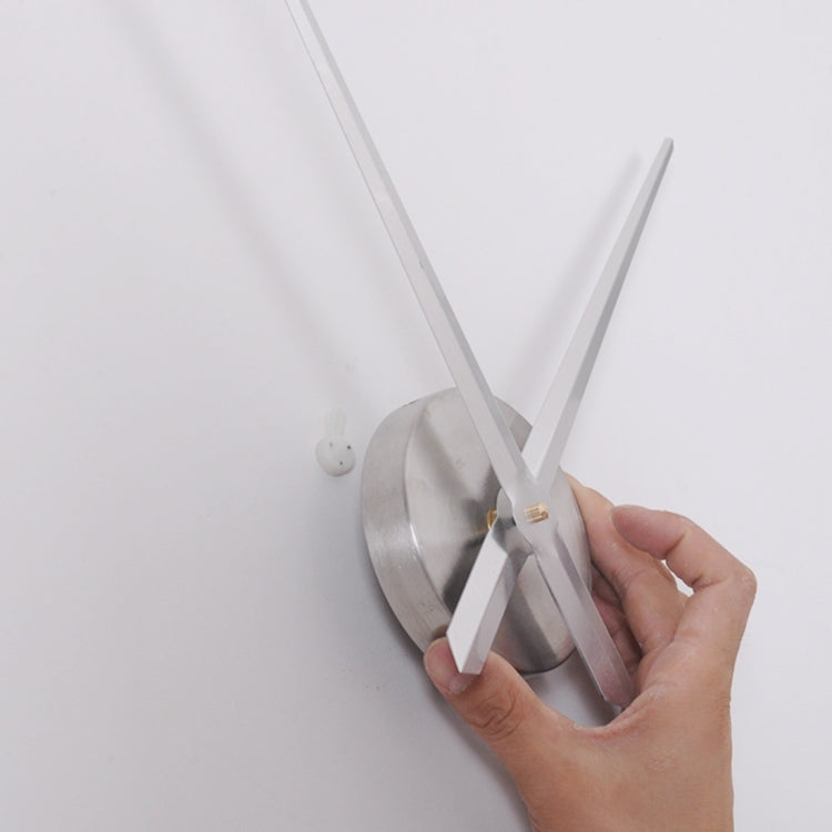 Hands attaching long white clock hands to a mirror-style silver clock center
