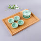Bamboo tea tray holding mint-green teacups and lidded teapot, 41x29 cm