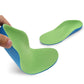 Children corrective insole, green top with blue edge, held in a hand for a close view.
