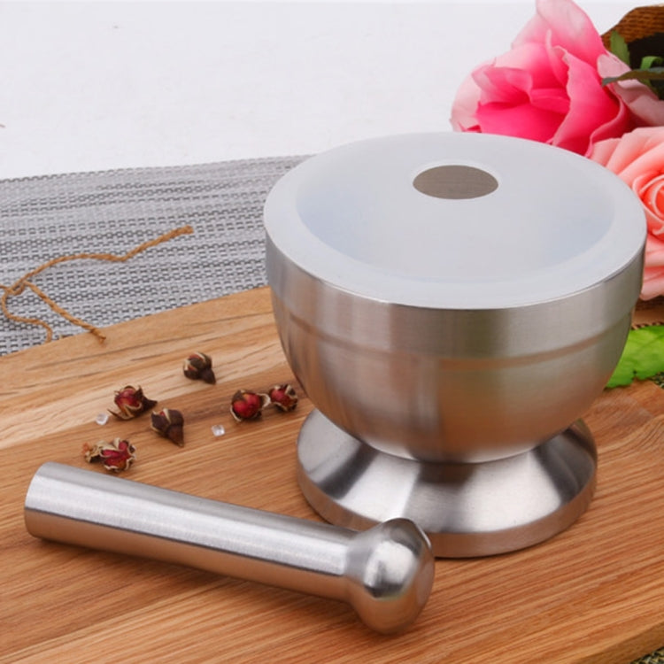 Stainless steel garlic mortar with lid and pestle resting on base