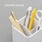 White desktop organizer box with compartments holding pens, scissors, and stationery