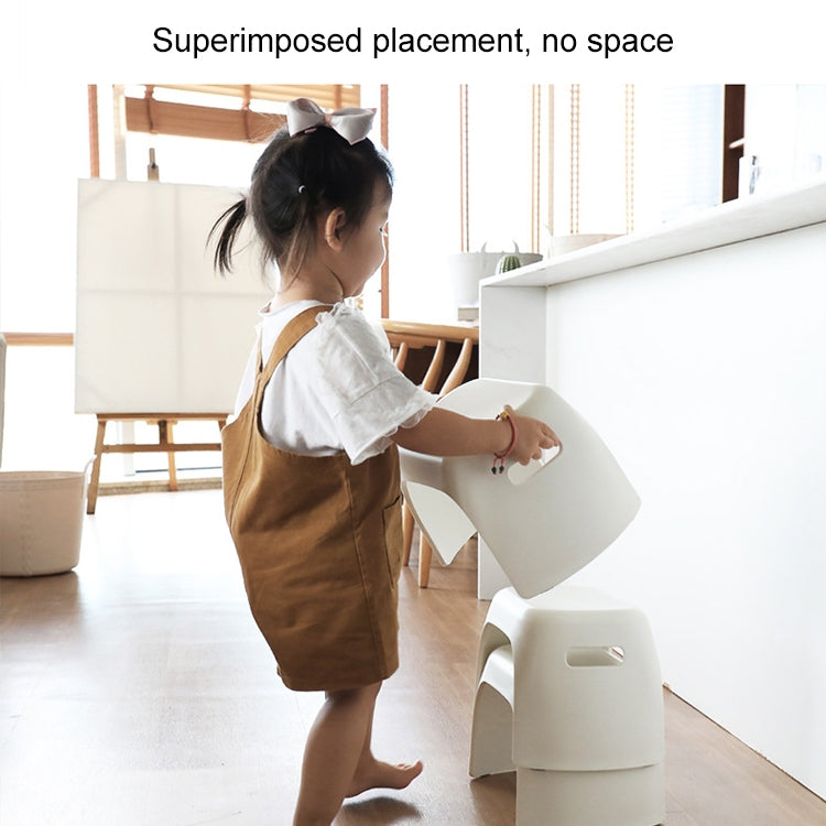 White plastic step stool in use by a child near a countertop