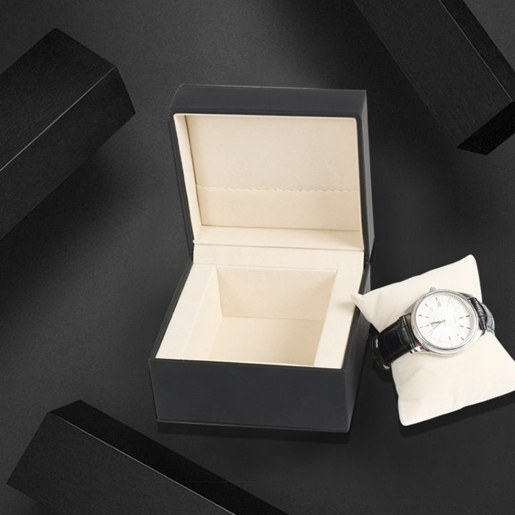 Black PU watch storage box with beige interior and watch on compartment base