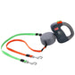 Gray retractable pet leash handle with green and orange dual straps and metal clips
