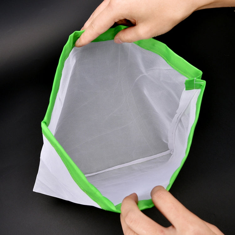 Green-trim reusable mesh food pouch with drawstring closure, held open by hands