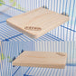 Light wood rectangular springboard with Carno logo, angled view inside pet cage.