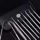 Stainless steel dentist tools with hooked and flat tips on textured black case fabric