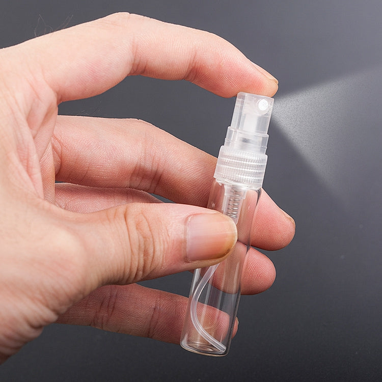 Close-up of a hand holding a clear mini perfume spray bottle with pump