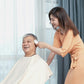 White handheld electric hair trimmer being used for haircut trimming