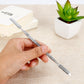 Hand holding metal makeup tools next to L-size square stainless steel mixing palette