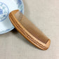 Brown wooden comb with carved sides and evenly spaced fine teeth