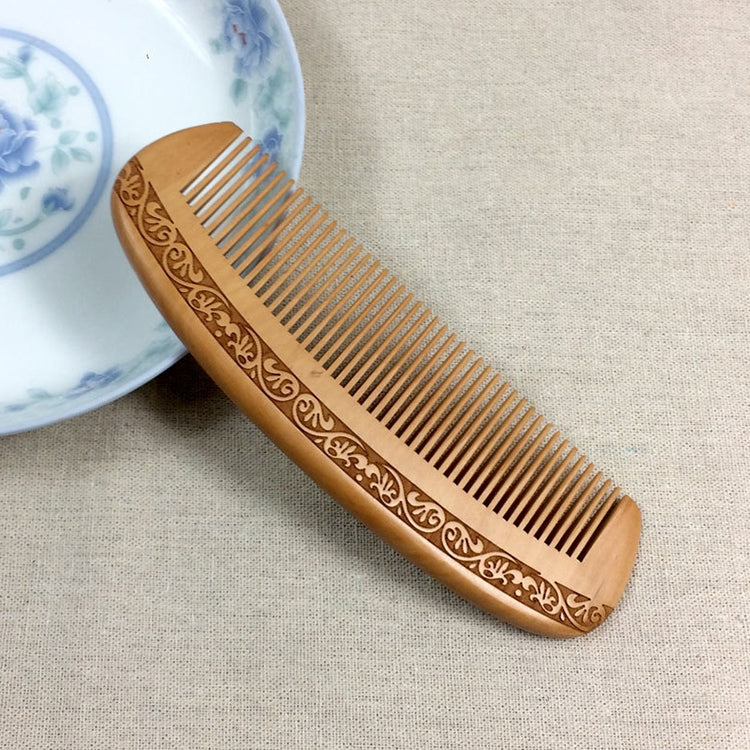 Brown wooden comb with carved sides and evenly spaced fine teeth