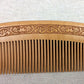 Close-up of brown comb teeth with engraved decorative border along top edge