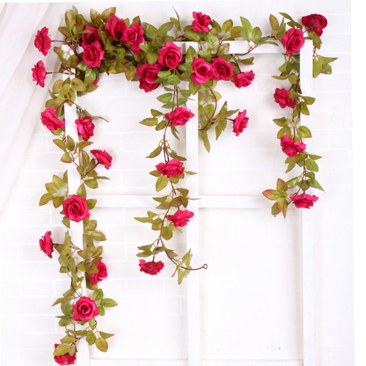 Artificial flower vine with pink rose-like blossoms and green leaves for hanging decor