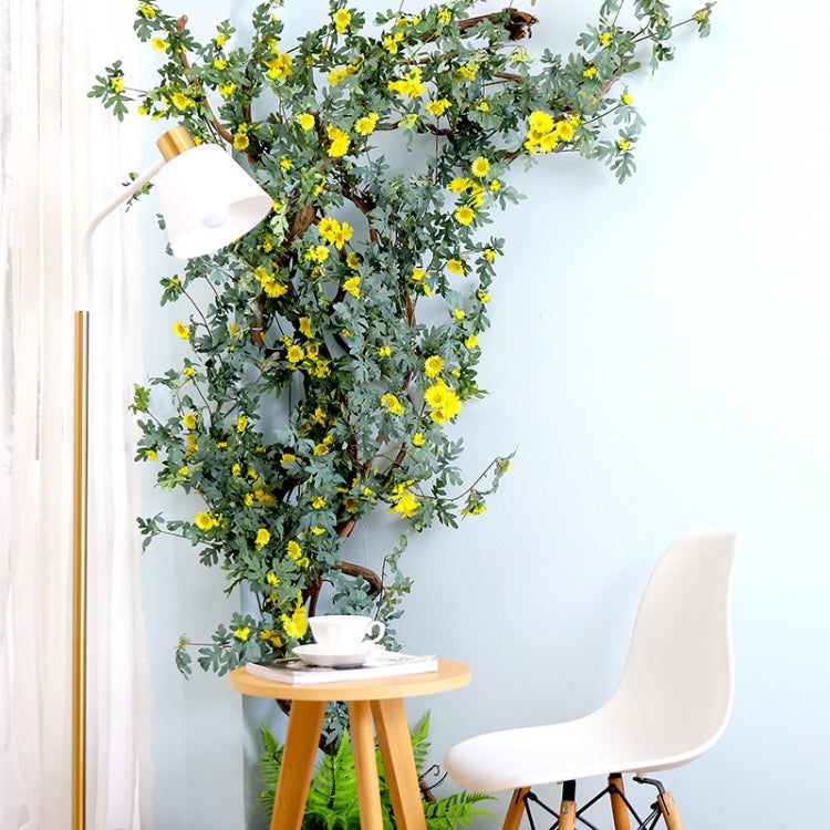 Artificial flower vine with yellow daisy blossoms and green leaves for interior decoration